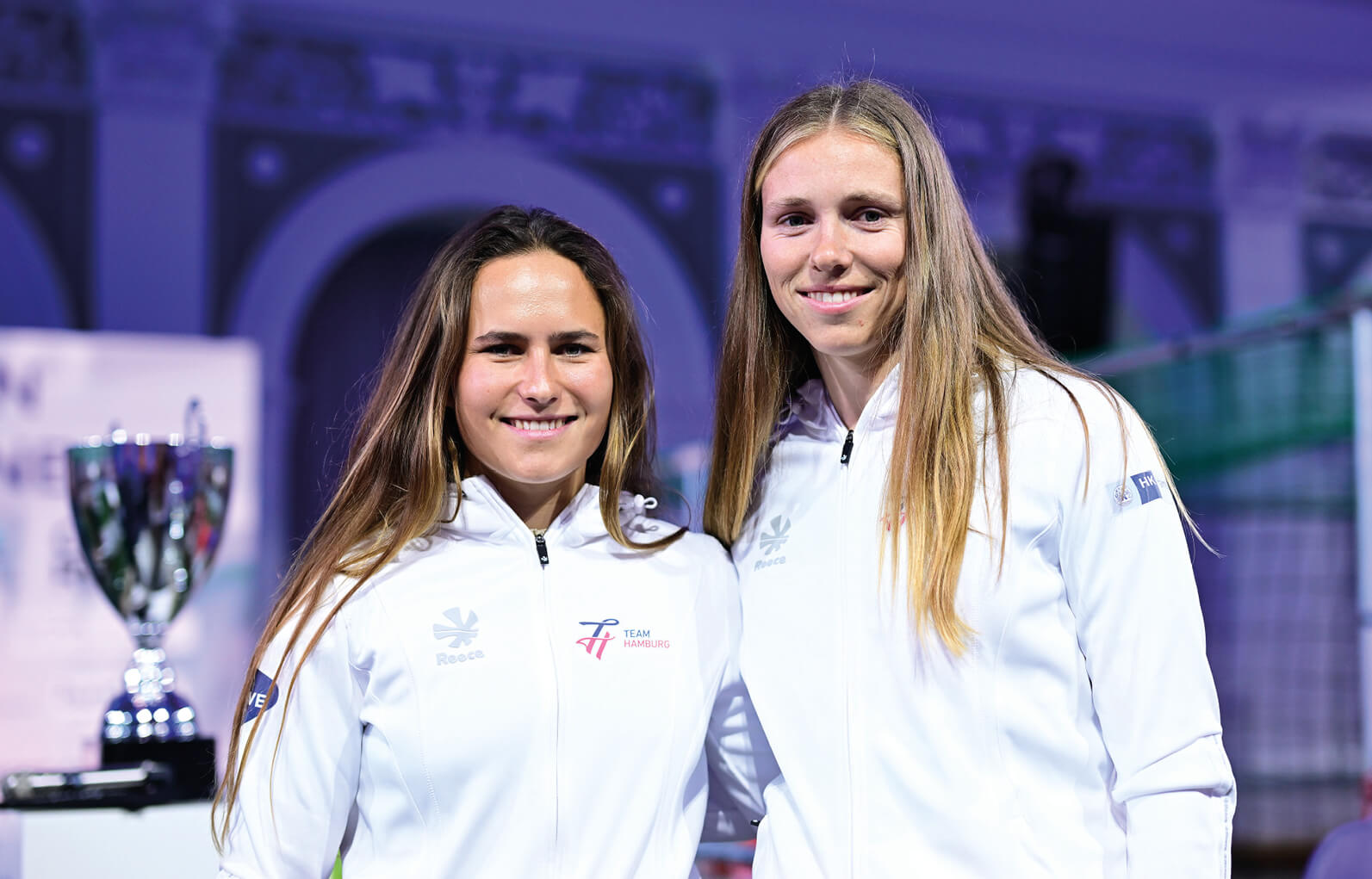 Sophie Steinlein und Catherine Bartelheimer in TEAM HAMBURG Jacken vor einem Pokal beim Handelskammer Cup 2025