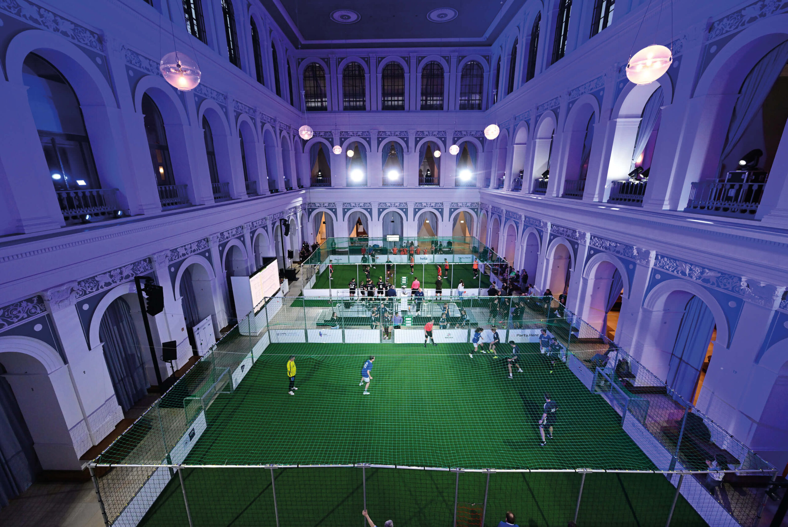 Börsensaal der Handelskammer Hamburg mit zwei Indoor-Fußballfeldern, spielenden Teams und Zuschauern