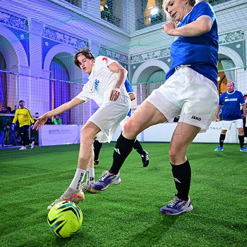 Frau vom Team HSB und Mann vom Team ETV im Zweikampf um den Ball beim Handelskammer Cup 2025 im Börsensaal Hamburg