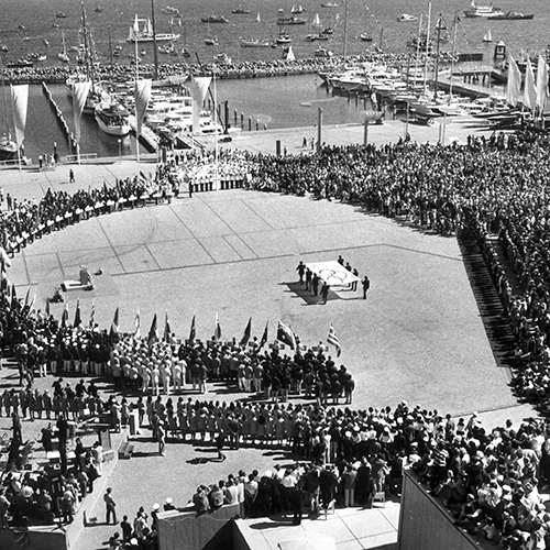 Olympische Eröffnungsfeier 1972 in Kiel-Schilksee am Wasser mit Zuschauern, Delegationen und olympischer Flagge
