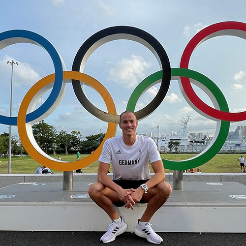 Jacob Heidtmann, Olympiateilnehmer 2016 und 2021, sitzt vor den Olympischen Ringen