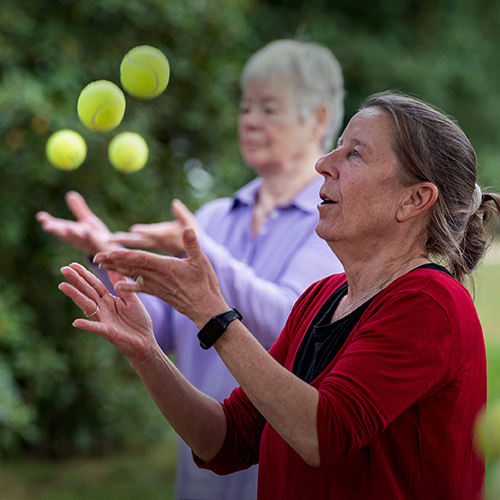 Zwei ältere Frauen jonglieren Tennisbälle in einem Hamburger Park als Beispiel für Bewegung im Alltag der Active City.