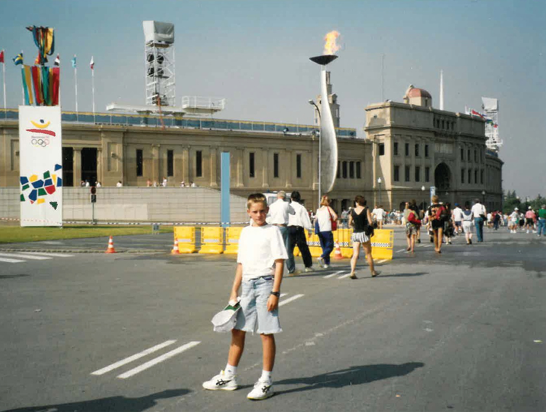 Daniel Knoblich mit 12 Jahren vor dem Olympiastadion 1992 in Barcelona, in Jeansshorts und weißem T-Shirt
