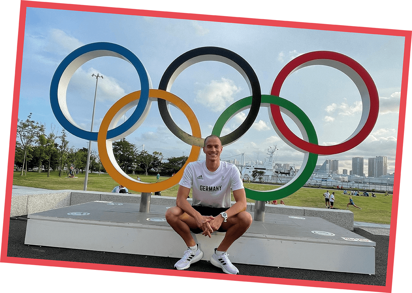 Jacob Heidtmann, Olympiateilnehmer 2016 und 2021, sitzt vor den Olympischen Ringen