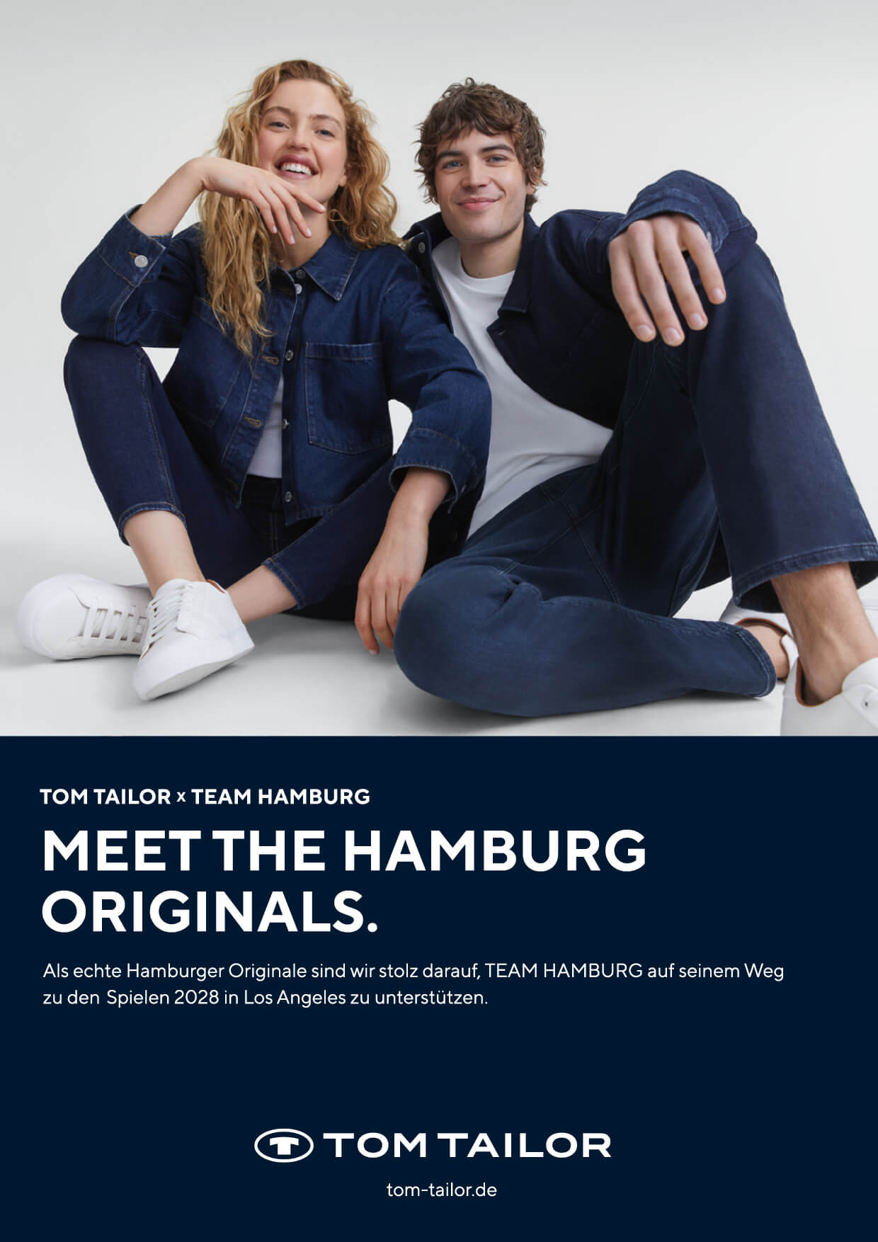 Frau und Mann in Denim-Outfits sitzen lachend auf weißem Boden – TOM TAILOR x TEAM HAMBURG Kampagne